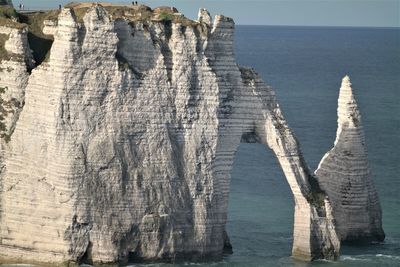 Panoramic view of rock formation in sea against sky