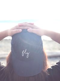 Close-up of woman hand holding heart shape against sky