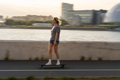 Full length of woman standing in city against sky