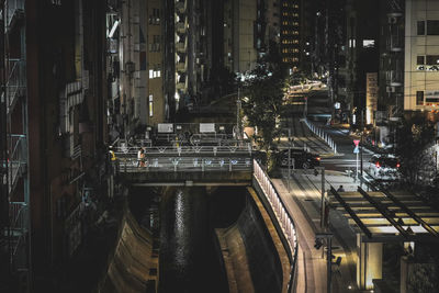 High angle view of illuminated street amidst buildings at night