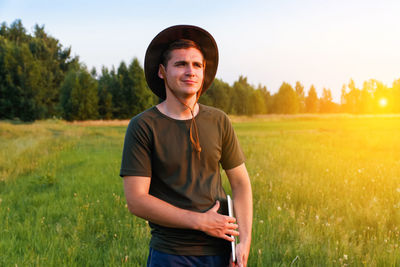Portrait of young man standing on field