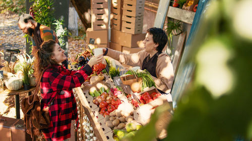 Rear view of woman holding food for sale at market