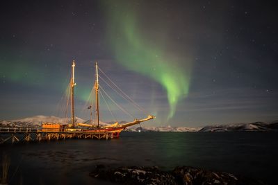 Scenic view of illuminated sea against sky at night