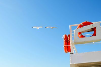 Low angle view of kite flying against blue sky