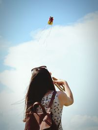 Low angle view of child standing against sky