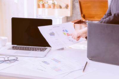 Midsection of man using laptop on table