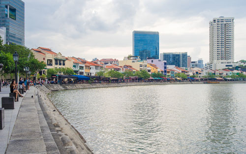 Buildings in city against cloudy sky