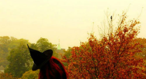 Close-up of a woman with autumn leaves in the background