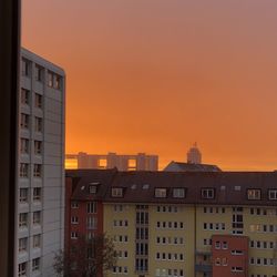 Residential buildings against sky during sunset