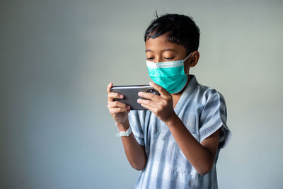 Young man using smart phone against white background