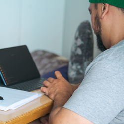 Midsection of man using laptop at home