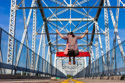 Rear view of man walking on bridge