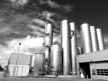 Low angle view of storage tanks against sky