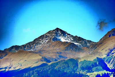 Scenic view of mountains against blue sky