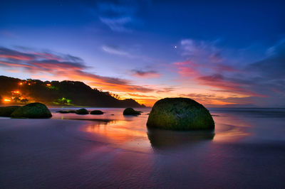 Scenic view of sea against dramatic sky during sunset