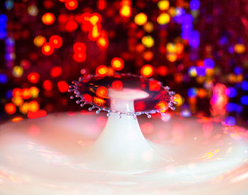 Close-up of water drop on illuminated table