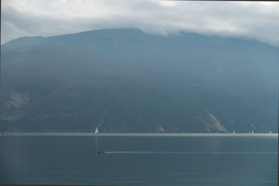 Scenic view of sea and mountains against sky