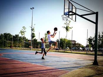 Men playing basketball hoop against sky