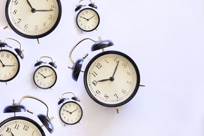 Low angle view of alarm clocks on white background