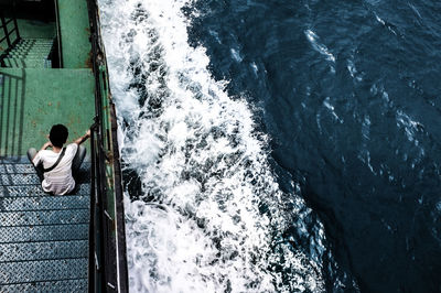 Rear view of man sitting on boat