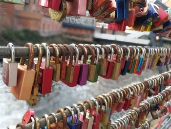 Close-up of love locks hanging in row on railing
