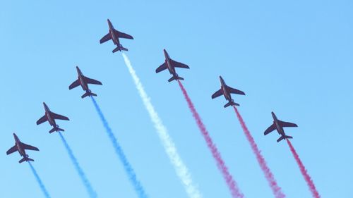 Low angle view of airshow against clear sky