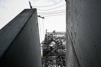 Low angle view of electricity pylon against sky