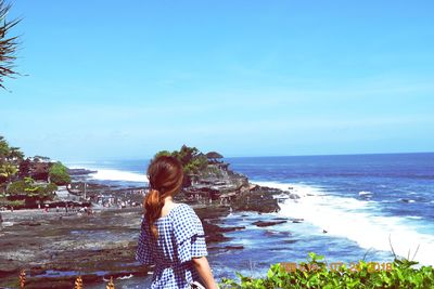 Rear view of woman looking at sea against sky