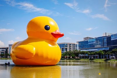 Close-up of yellow toys in water against sky