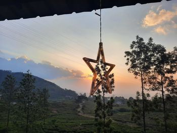 Silhouette windmill on mountain against sky during sunset