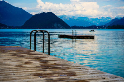 Pier over lake against cloudy sky