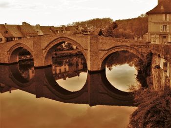 Arch bridge over river against sky