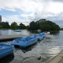 Boats moored in lake against sky