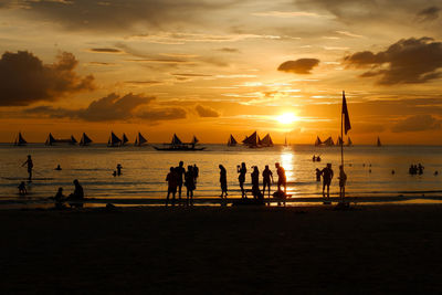 Silhouette people at beach during sunset