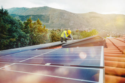 Rear view of man walking on solar panel