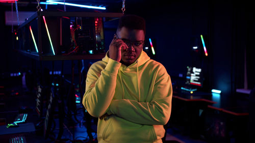 Portrait of young man standing in internet cafe