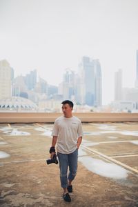 Full length of man standing on city buildings against sky