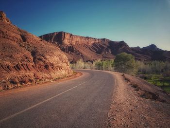 Road by mountain against clear sky