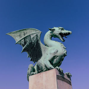 Low angle view of statue against clear blue sky