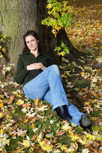 Portrait of young woman relaxing on field during autumn at herrenhausen gardens