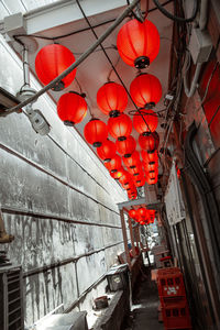 Low angle view of illuminated lanterns hanging by building