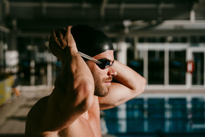 Handsome male swimmer preparing for swimming on sunny day