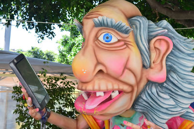 Close-up of girl holding toy against trees