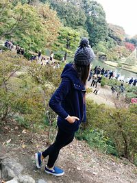 Full length of woman standing on tree trunk