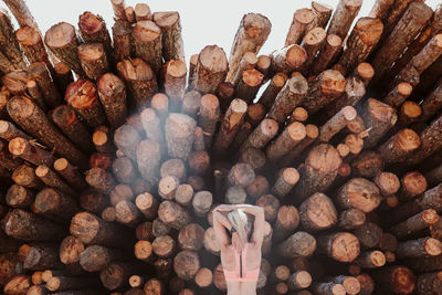 Woman against stack of logs