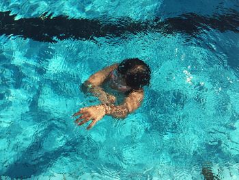 High angle view of boy swimming in pool