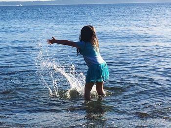 Rear view of woman standing in sea