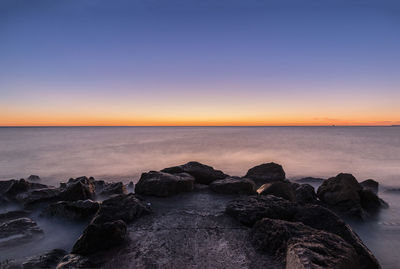 Scenic view of sea against clear sky during sunset