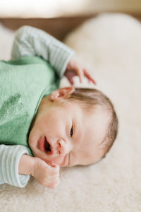 Portrait of cute baby lying on bed