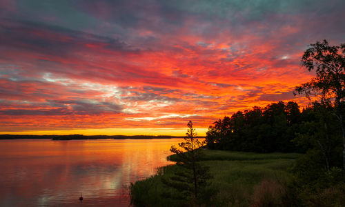 Scenic view of lake against orange sky at sunrise